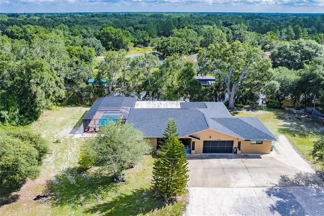 an aerial view of a house with swimming pool and garden