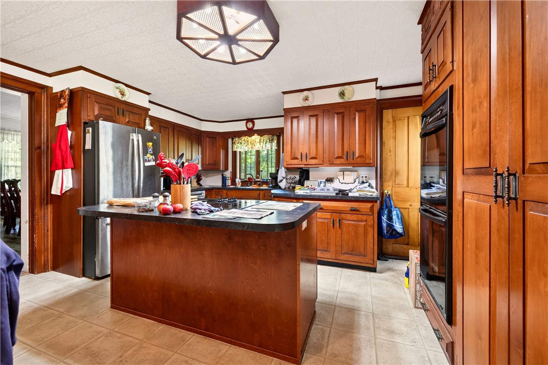 7780 Cold Springs Road Bath, NY 14810 - Photo 7 of 50 Rich wood cabinetry and a central island ground this functional kitchen layout.