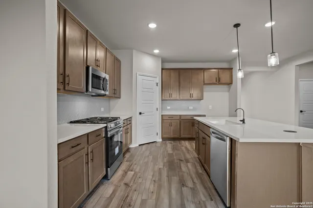 a kitchen with stainless steel appliances granite countertop a sink stove and refrigerator