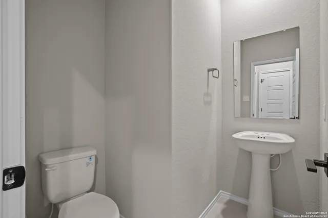 a bathroom with a toilet sink and mirror