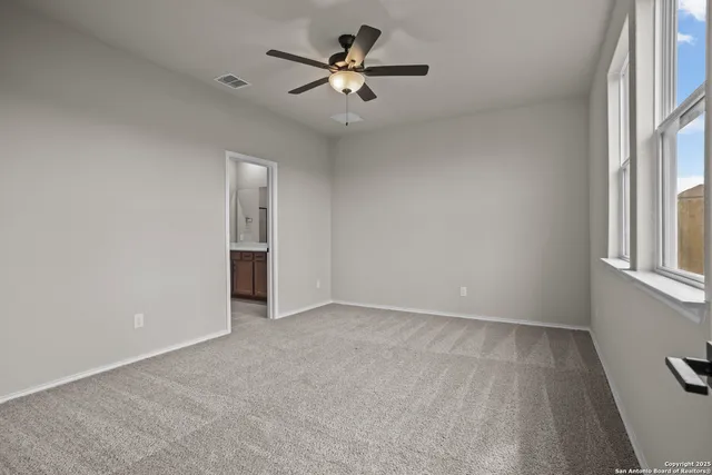 an empty room with fan and windows