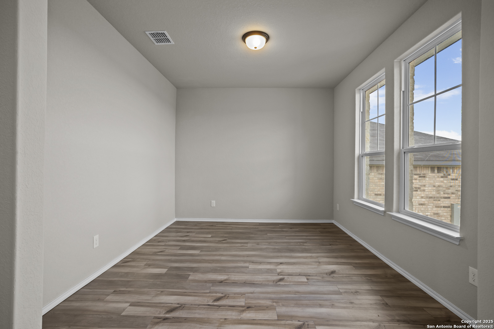 6871 Comanche Cave San Antonio, TX 78233 - Photo 7 of 41 a view of an empty room with wooden floor and a window