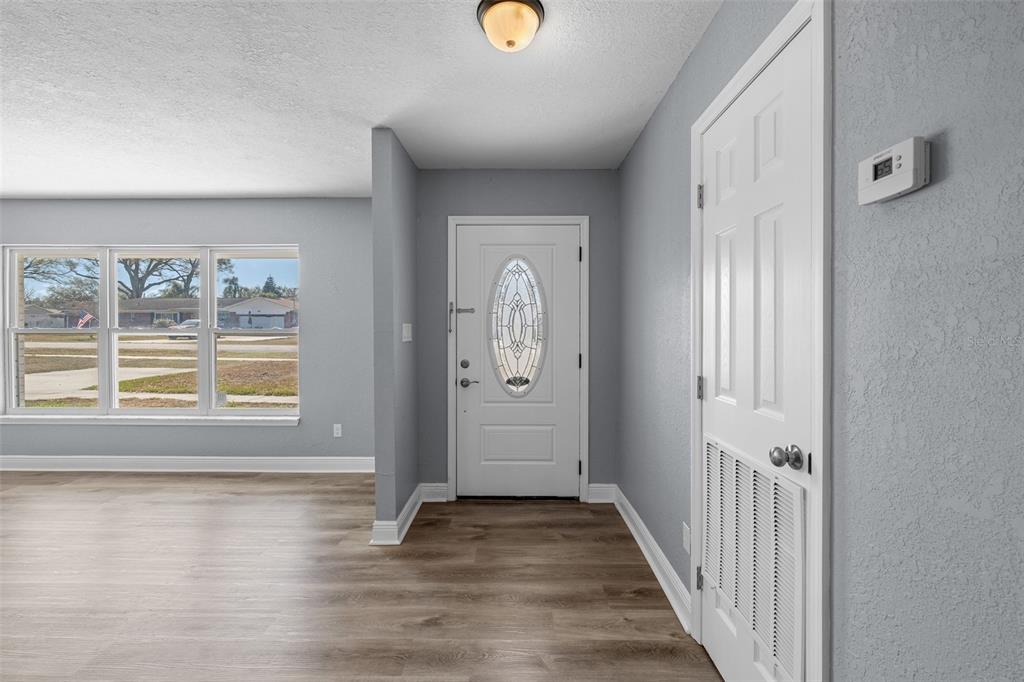 606 Bama Road Brandon, FL 33511 - Photo 3 of 44 a view of a hallway to a livingroom with wooden floor and window