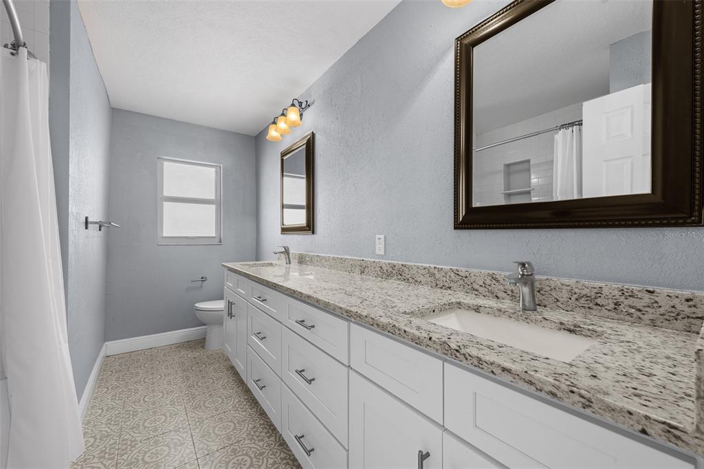 606 Bama Road Brandon, FL 33511 - Photo 33 of 44 a bathroom with a granite countertop sink mirror and cabinets