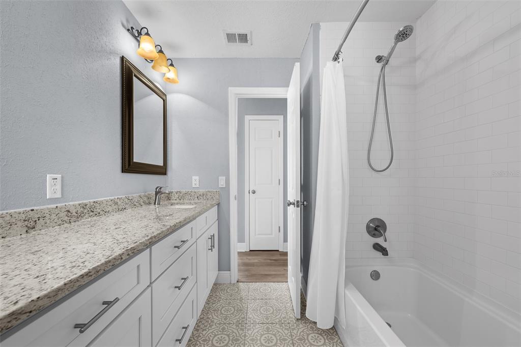 606 Bama Road Brandon, FL 33511 - Photo 34 of 44 a bathroom with a granite countertop sink two mirror a bathtub and shower