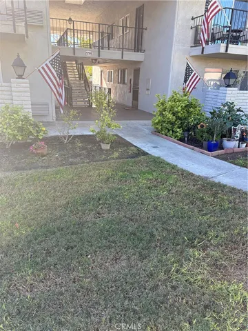 a view of a house with a yard and potted plants