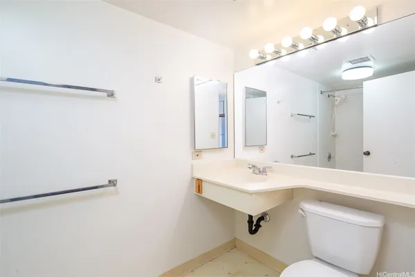 a bathroom with a sink mirror vanity and toilet
