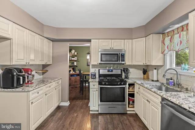 a kitchen with stainless steel appliances a stove sink microwave and cabinets