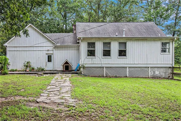 a view of a house with backyard and trees