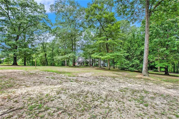 an aerial view of residential house with outdoor space and trees all around
