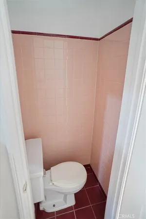 a white toilet sitting next to a small window