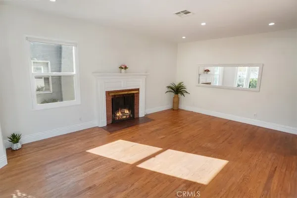 a view of empty room with wooden floor and fireplace