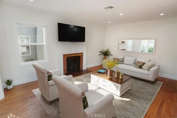 a living room with furniture a fireplace and a flat screen tv