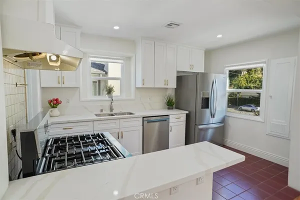 a kitchen with a stove a refrigerator and a sink