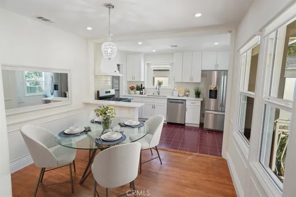 a view of kitchen with refrigerator a stove and wooden floor