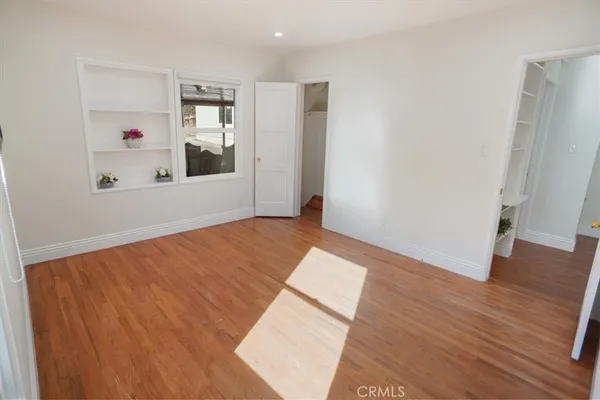 a view of a room with wooden floor and hallway