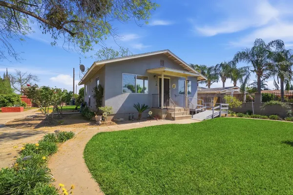 a front view of a house with patio and garden