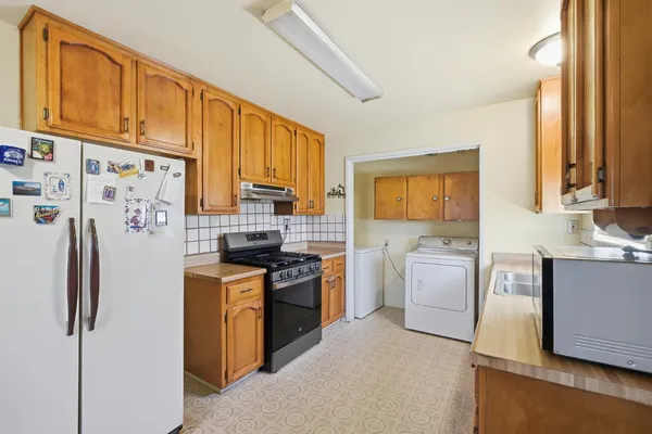 a kitchen with stainless steel appliances granite countertop a refrigerator stove and sink