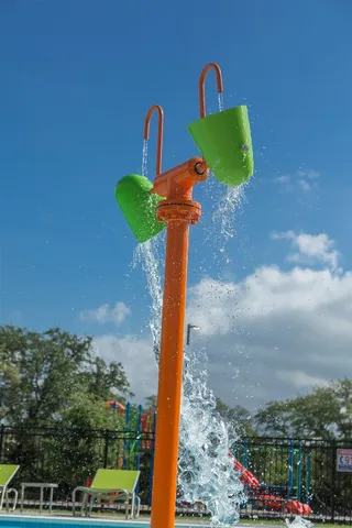 a view of a park with a slide and a lake view