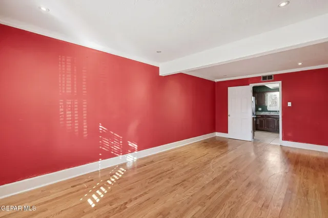 a view of an empty room with wooden floor