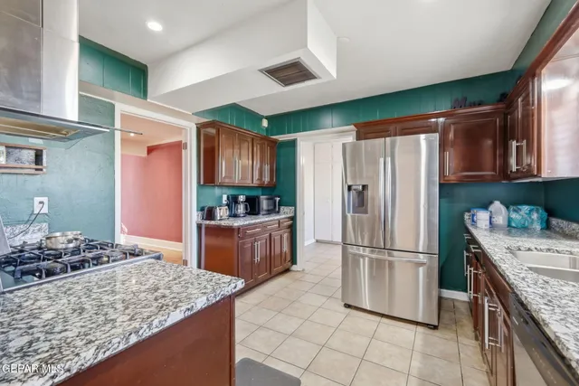 a kitchen with stainless steel appliances granite countertop a refrigerator and a sink