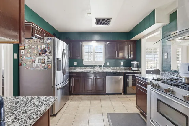 a kitchen with stainless steel appliances granite countertop a stove a refrigerator and a sink