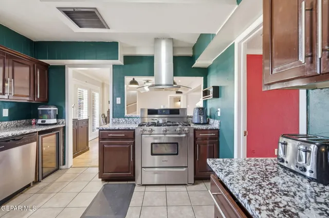 a kitchen with stainless steel appliances granite countertop a stove and a refrigerator