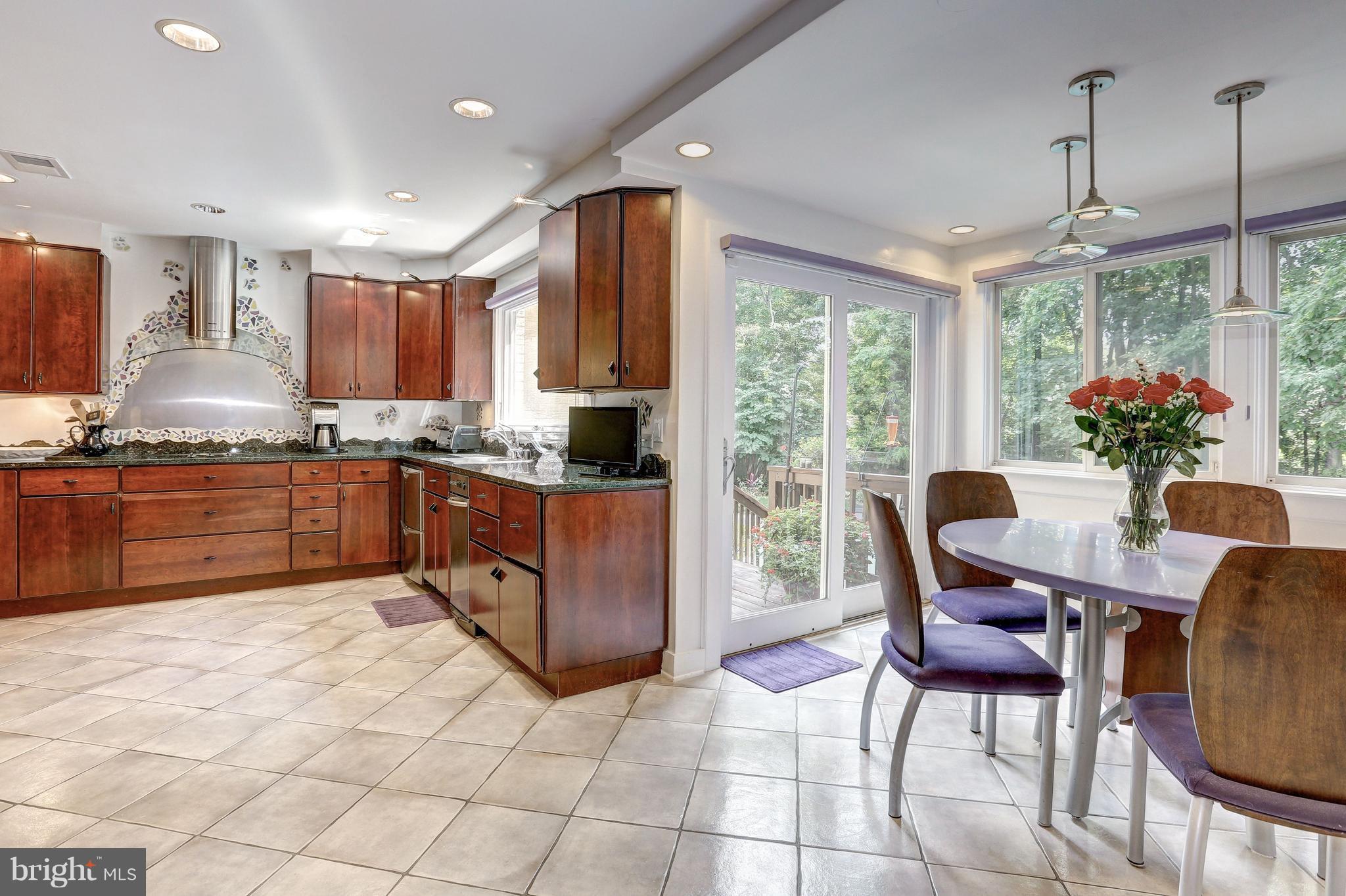 10101 Ormond Road Potomac, MD 20854 - Photo 11 of 30 a kitchen with stainless steel appliances granite countertop a table chairs and a refrigerator