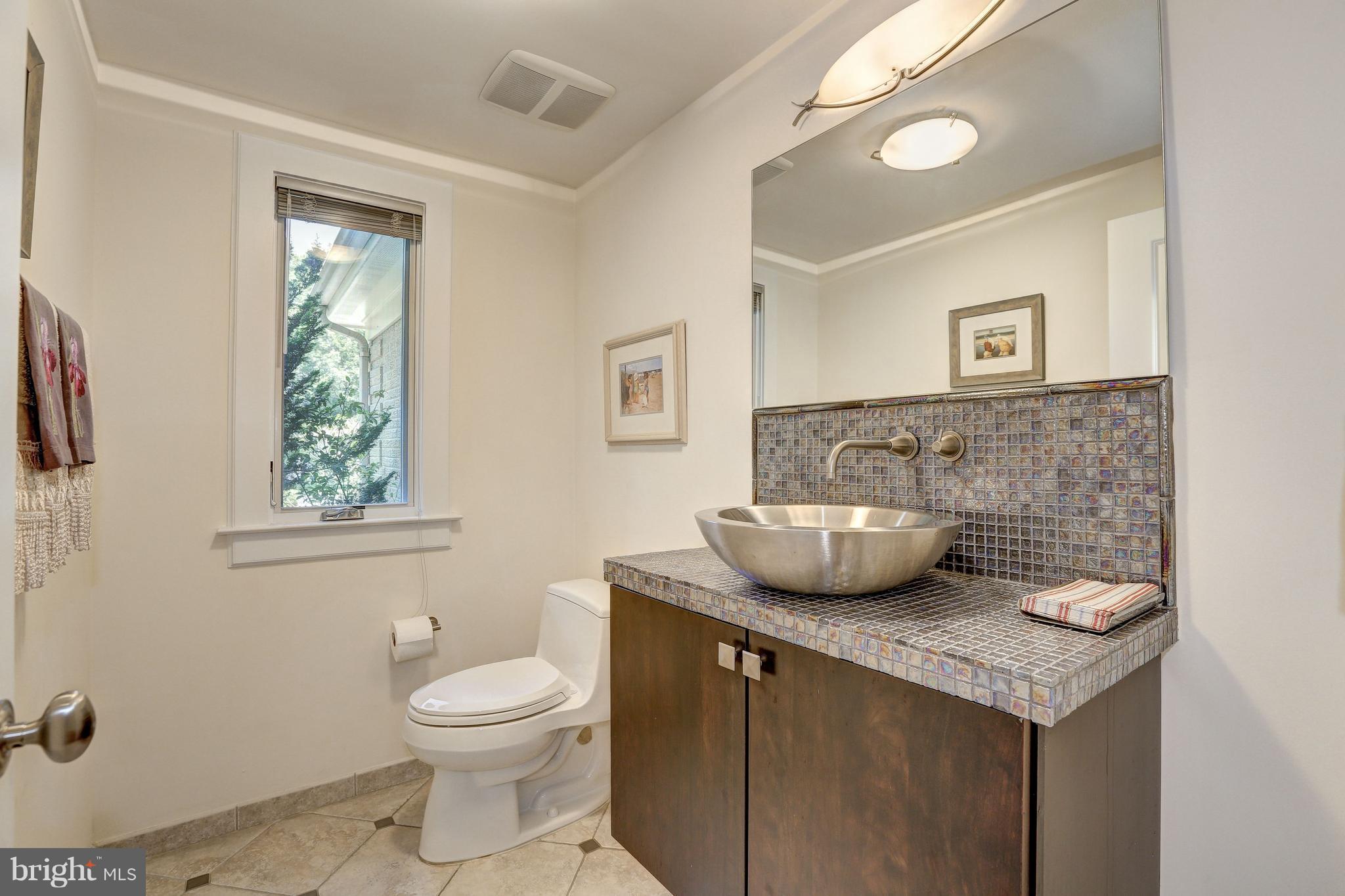 10101 Ormond Road Potomac, MD 20854 - Photo 15 of 30 a bathroom with a granite countertop toilet a sink and a mirror