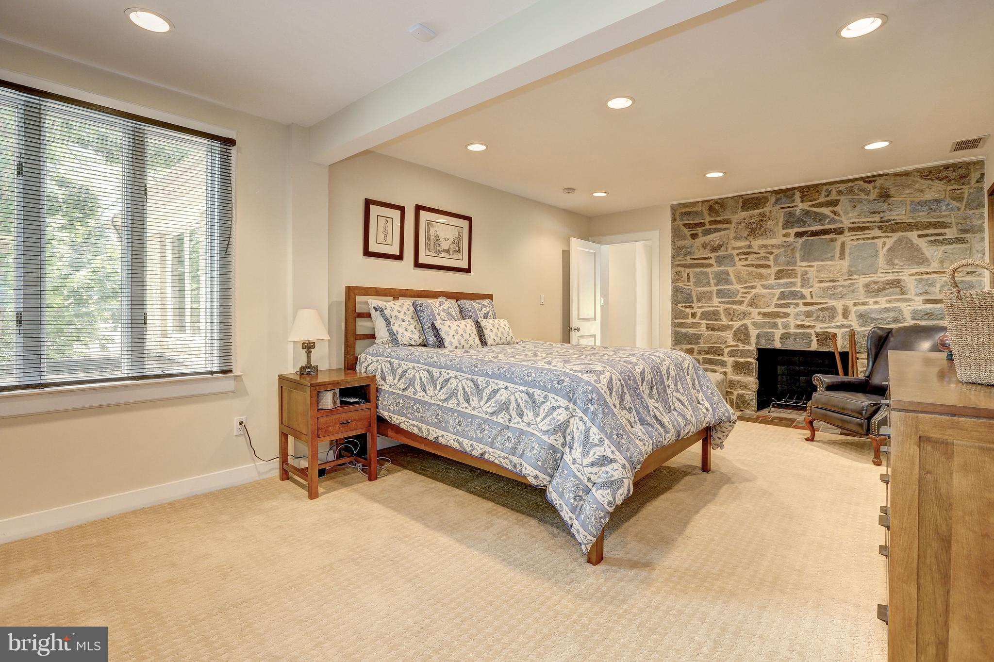 10101 Ormond Road Potomac, MD 20854 - Photo 23 of 30 a spacious bedroom with a bed and a fireplace