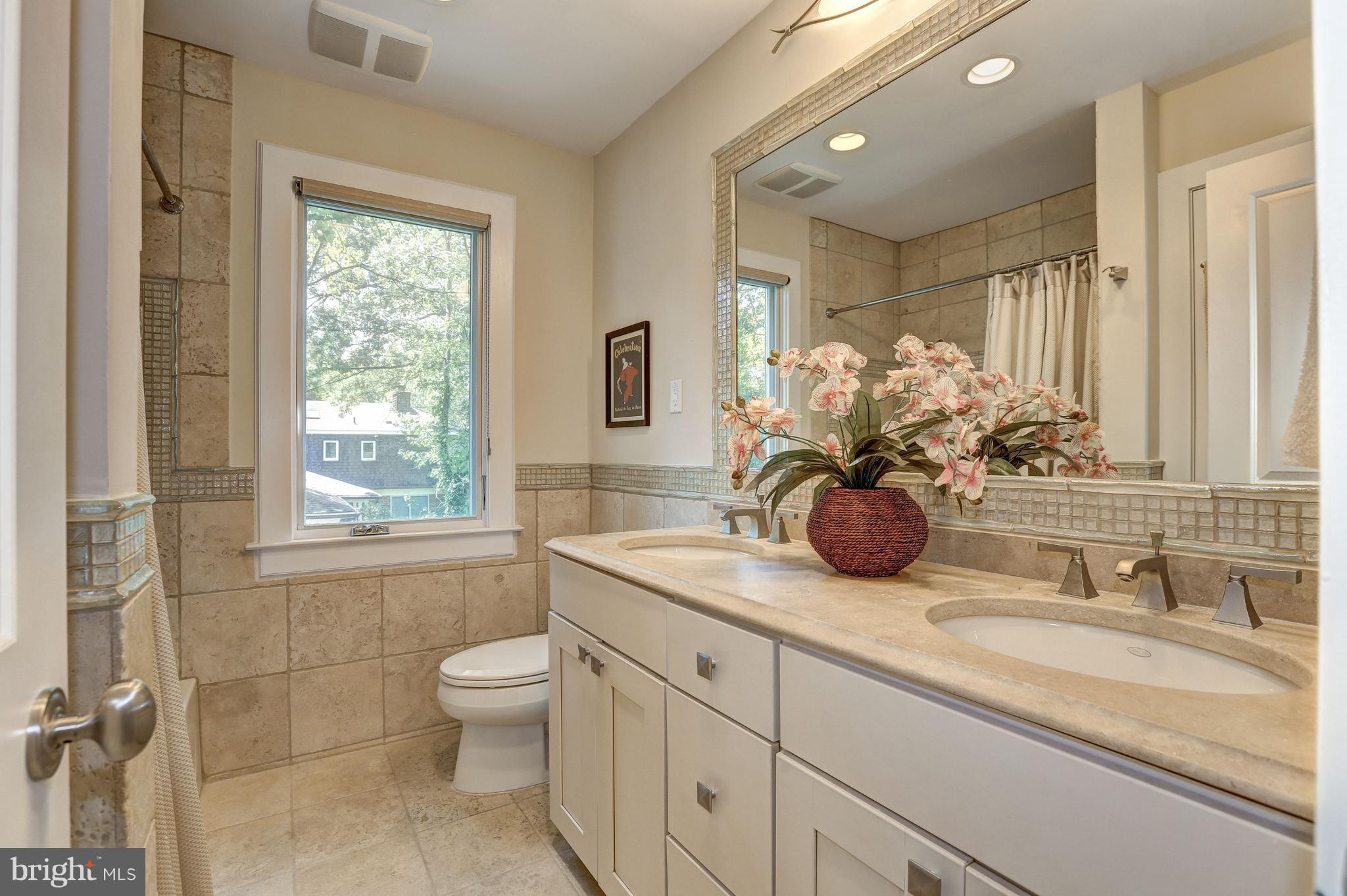 10101 Ormond Road Potomac, MD 20854 - Photo 26 of 30 a bathroom with double vanity a toilet a and mirror