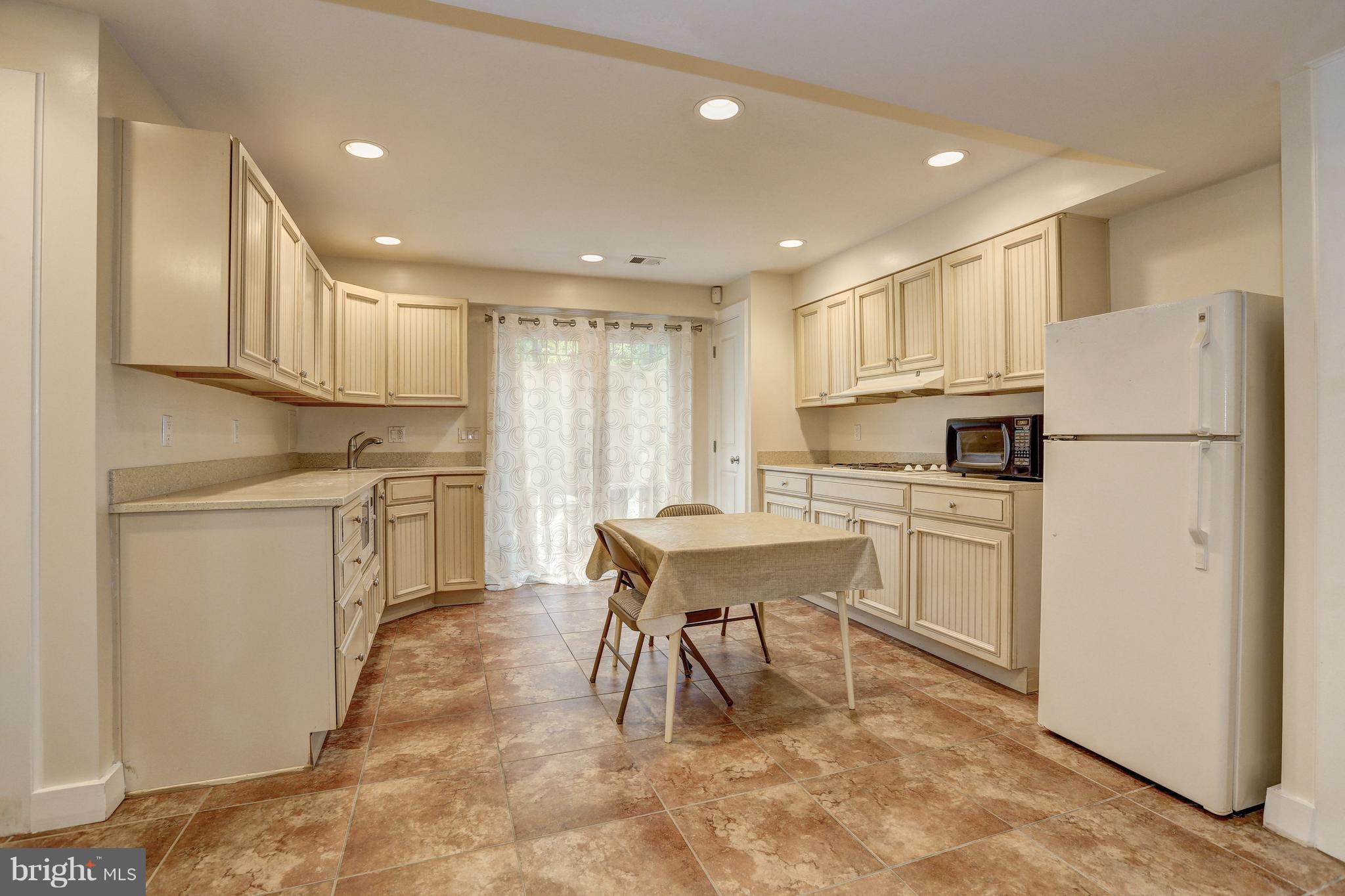 10101 Ormond Road Potomac, MD 20854 - Photo 29 of 30 a kitchen with white cabinets and white appliances