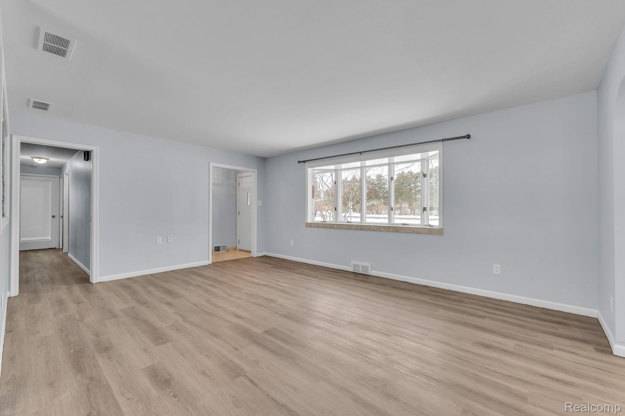 6576 Inkster Road West Bloomfield, MI 48322 - Photo 11 of 62 Unfurnished living room featuring light wood-style flooring and baseboards