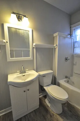 a view of a hallway with wooden floor and window