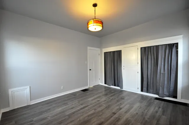 an empty room with wooden floor and window