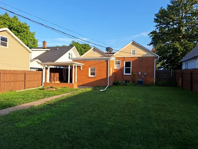 a view of a backyard with a garden and wooden fence