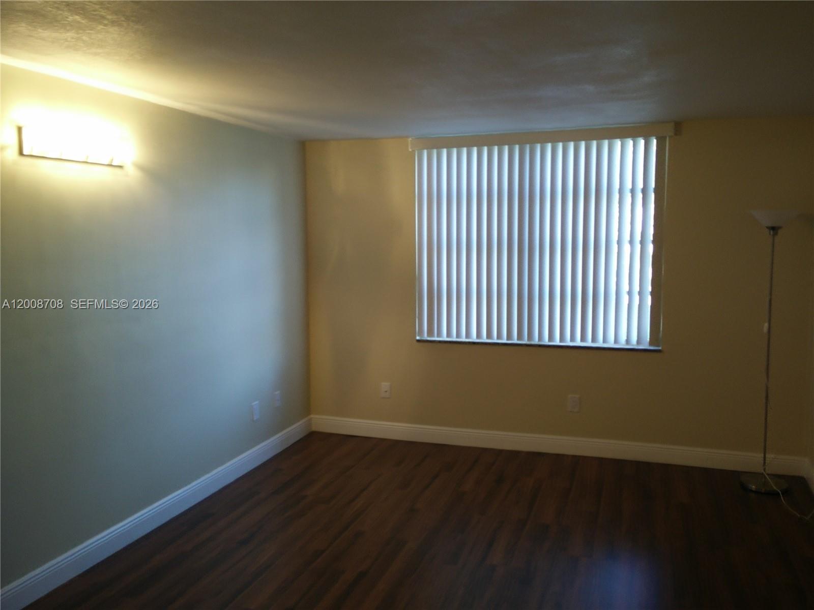 3285 Foxcroft Road, Unit E107 Miramar, FL 33025 - Photo 7 of 12 an empty room with wooden floor and windows