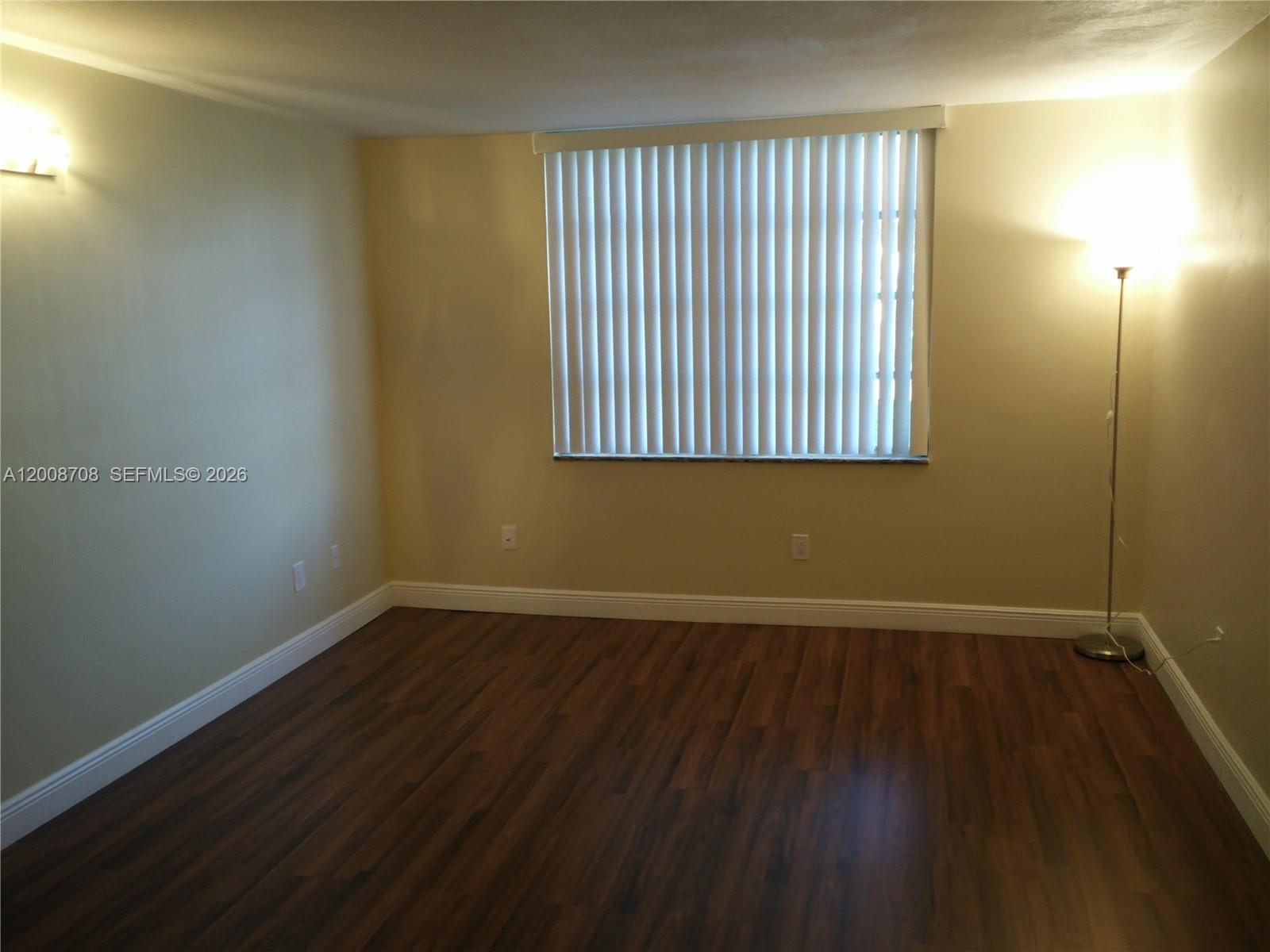 3285 Foxcroft Road, Unit E107 Miramar, FL 33025 - Photo 8 of 12 an empty room with wooden floor and windows