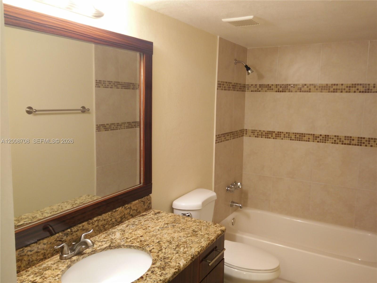 3285 Foxcroft Road, Unit E107 Miramar, FL 33025 - Photo 9 of 12 a bathroom with a granite countertop sink toilet and shower
