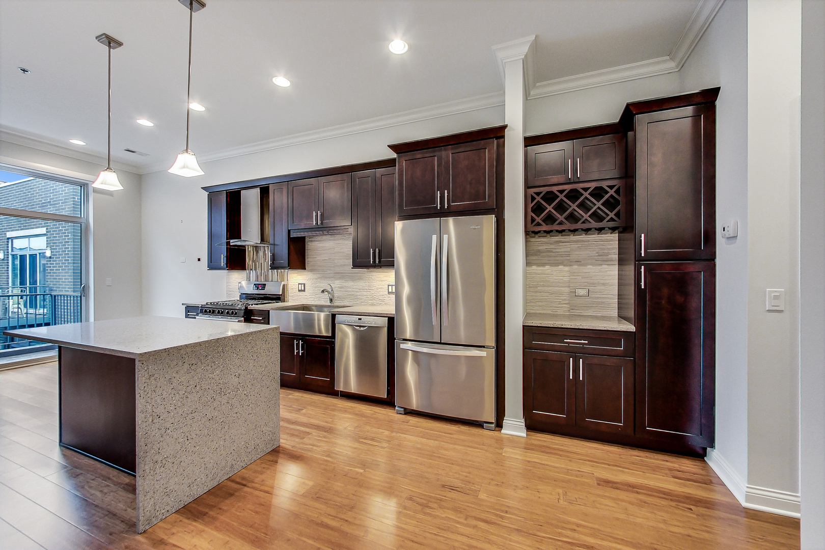 1247 West Madison Street, Unit 310 Chicago, IL 60607 - Photo 2 of 11 a kitchen with kitchen island a counter top space a refrigerator and a sink
