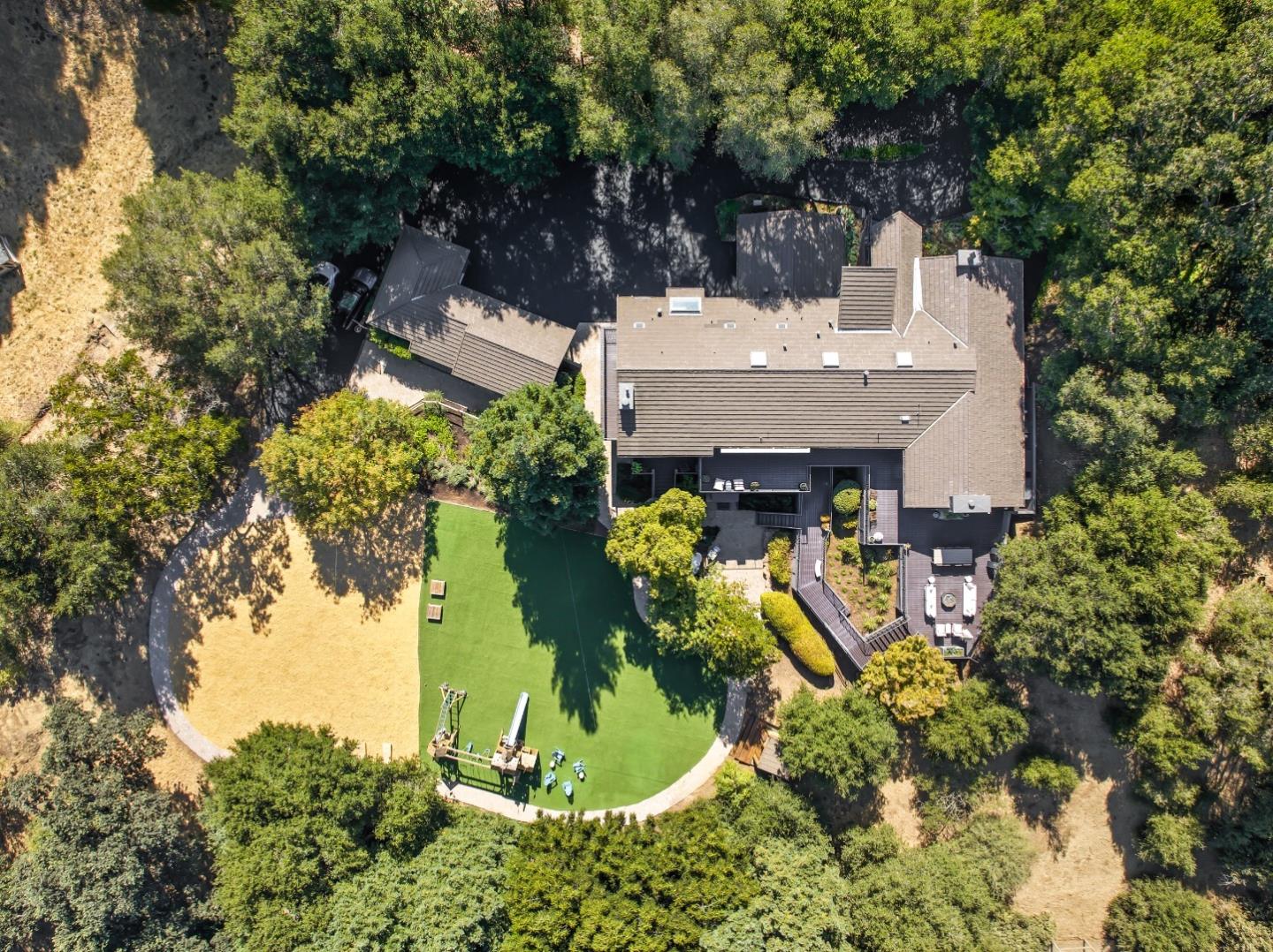 an aerial view of a house with a yard basket ball court and outdoor seating