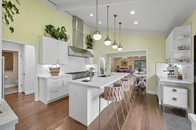 a kitchen with stainless steel appliances granite countertop a sink a stove and a refrigerator