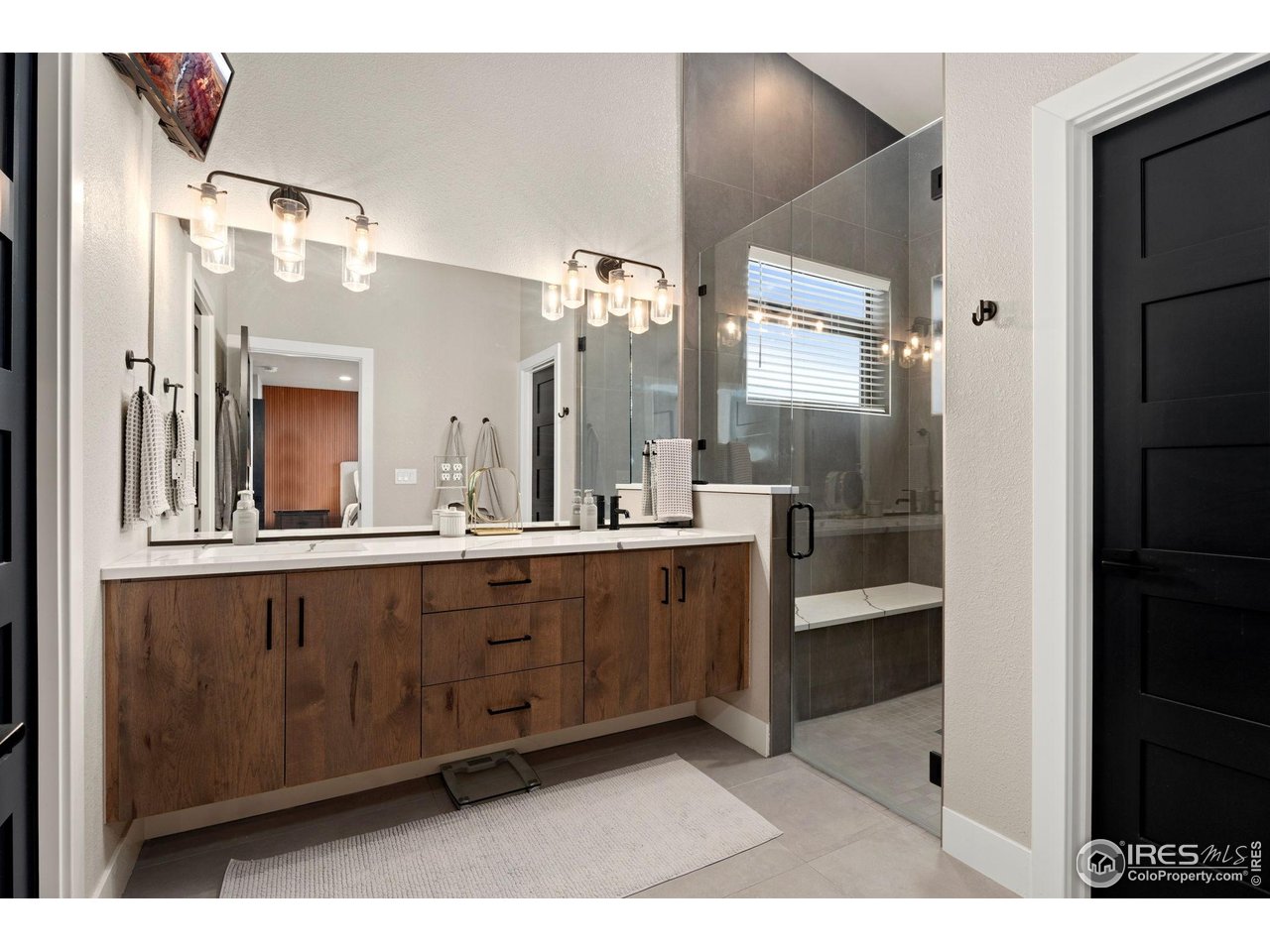 2089 Picture Point Drive Windsor, CO 80550 - Photo 18 of 45 a bathroom with a sink a large mirror and a shower