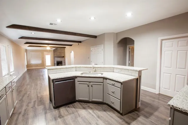 a large kitchen with a sink a stove and a refrigerator