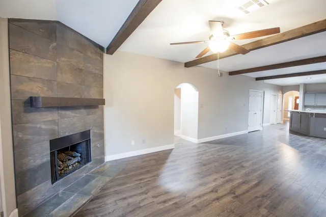 a view of a livingroom with wooden floor and a fireplace