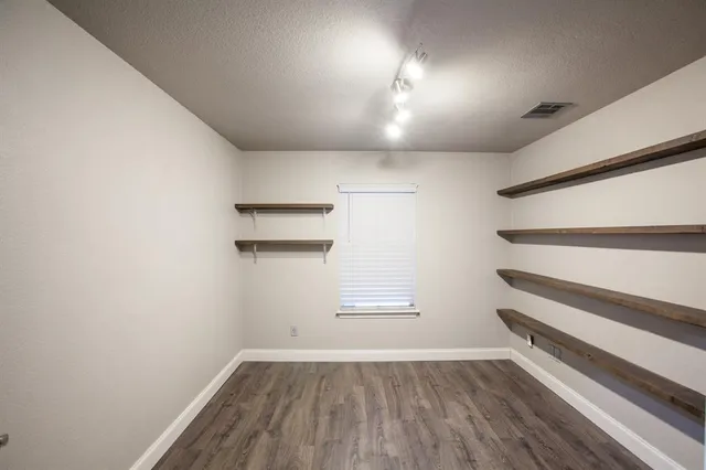 a view of walk in closet with empty racks