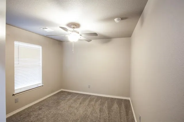 an empty room with chandelier fan