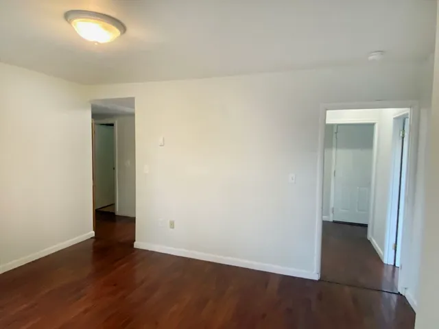an empty room with wooden floor and a window