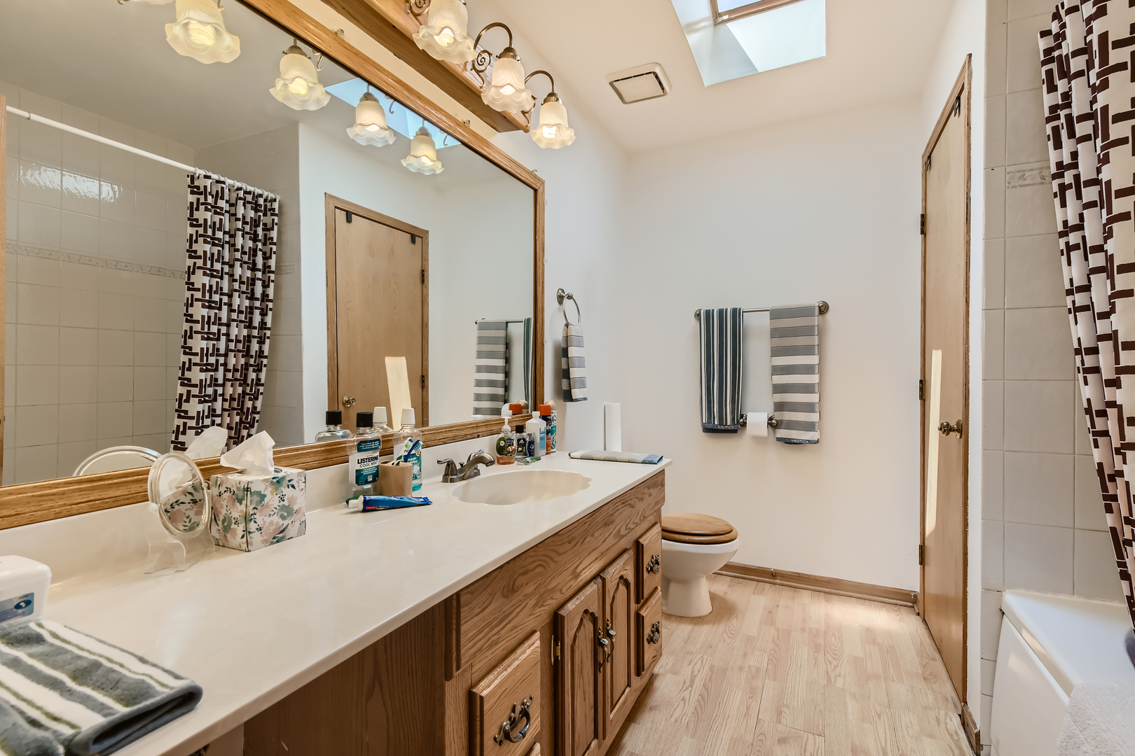 4057 Custer Avenue Lyons, IL 60534 - Photo 15 of 28 a bathroom with double vanity sinks a toilet and a large mirror