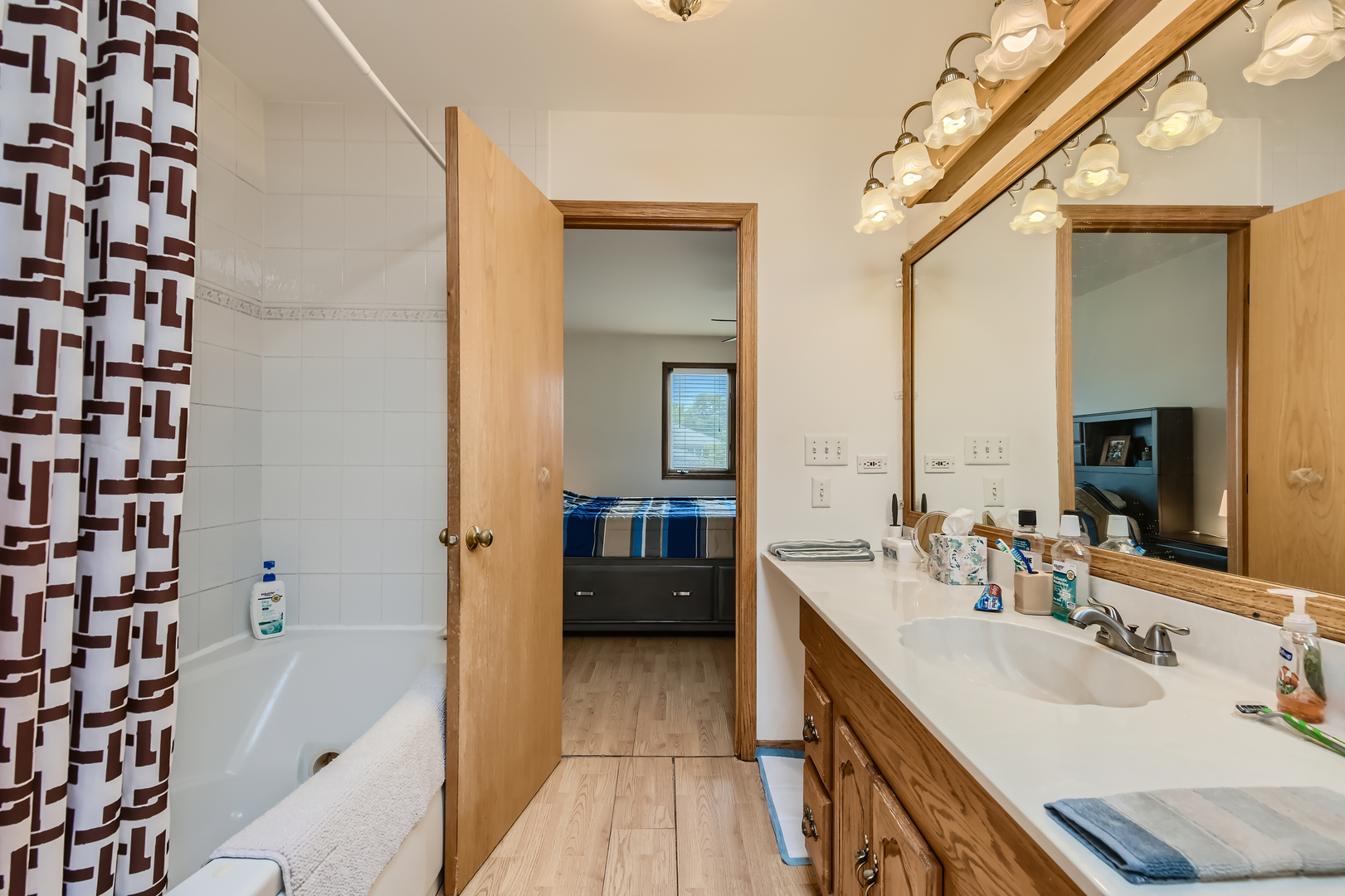 4057 Custer Avenue Lyons, IL 60534 - Photo 16 of 28 a en suite bathroom with a double vanity sink a mirror and a bathtub
